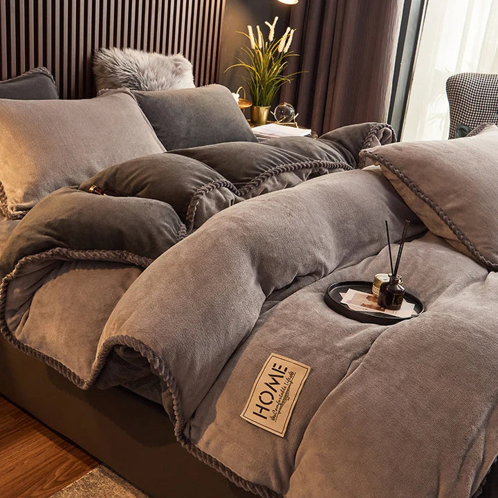 Graues, flauschiges Bettwäsche-Set aus Samt mit Kissen und Decke im modernen Schlafzimmer.