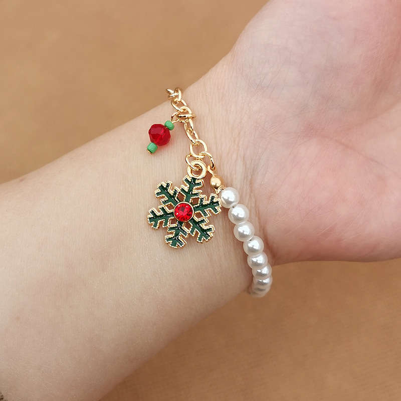 Goldenes Armband mit Schneeflocken-Anhänger und Perlen, weihnachtlicher Schmuck, Damenaccessoire.