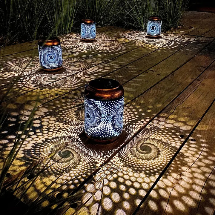 Solarbetriebene Gartenlaternen aus Metall, spiralförmiges Muster, stimmungsvolle Beleuchtung, Nacht.