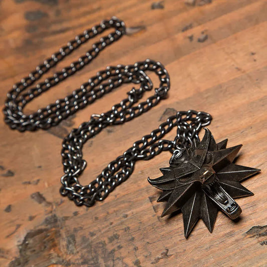 Schwarze Edelstahlkette mit sternförmigem Anhänger auf Holzoberfläche.