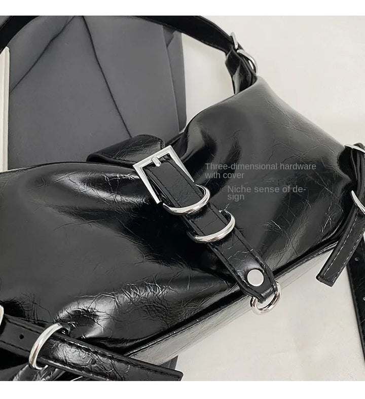 Schwarze Lederhandtasche mit Schnallen, dreidimensionaler Hardware, modisches Design.