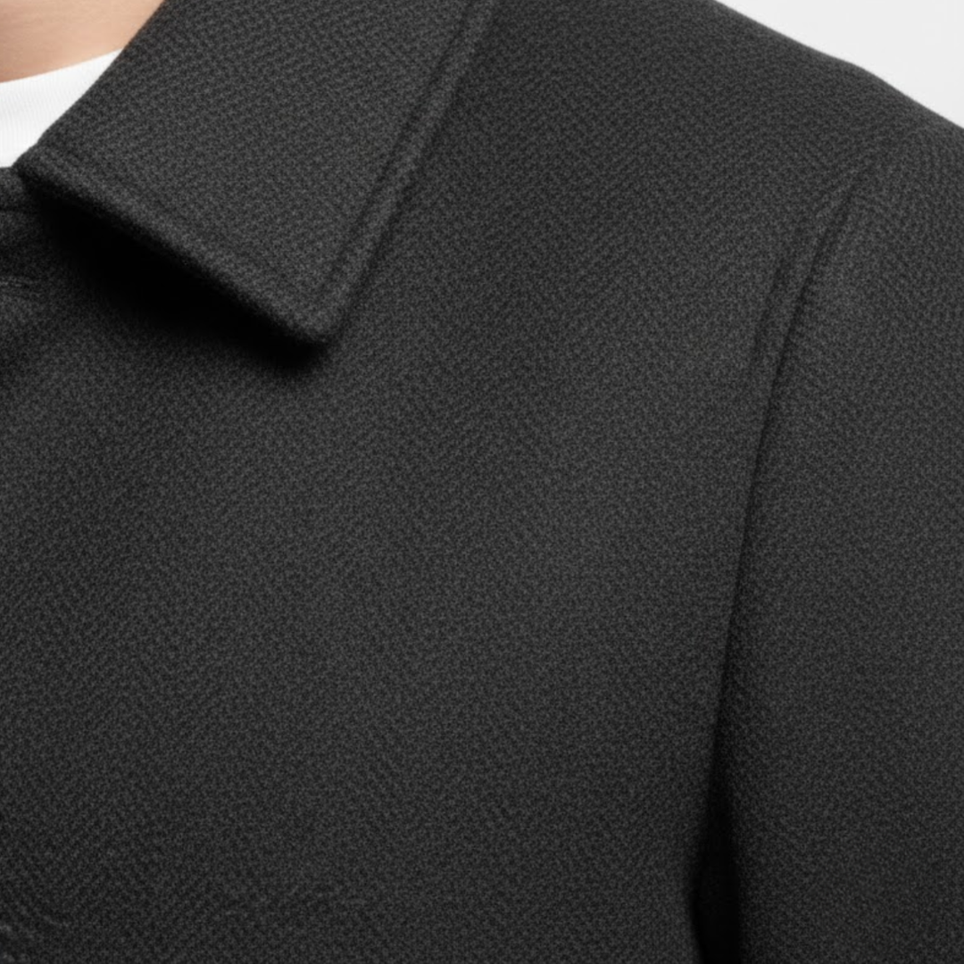 Detail klopy a ramene černého kabátu s viditelnou strukturou jemně tkané látky 7