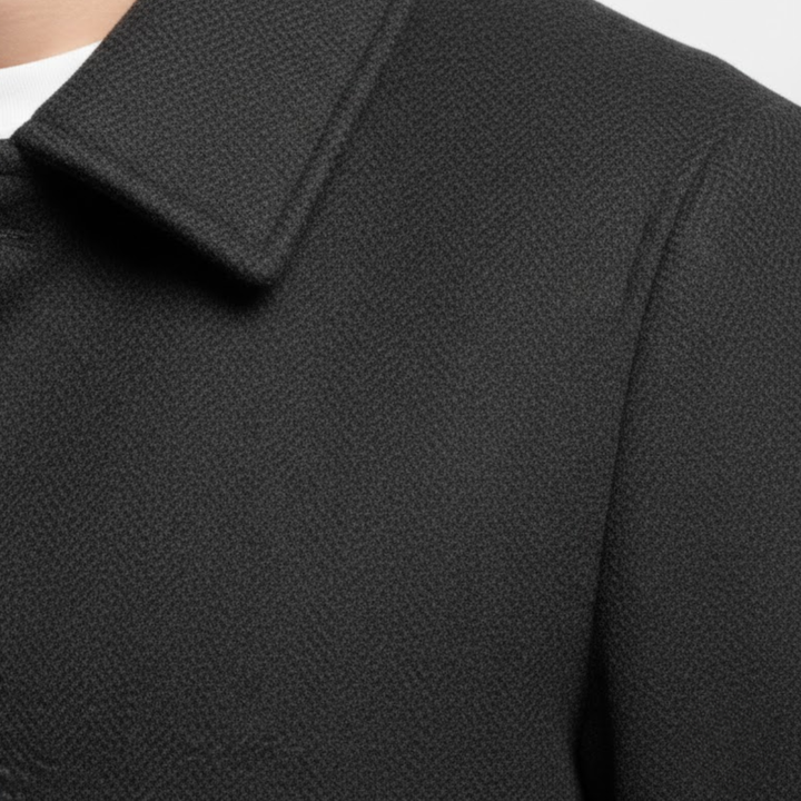 Detail klopy a ramene černého kabátu s viditelnou strukturou jemně tkané látky 7