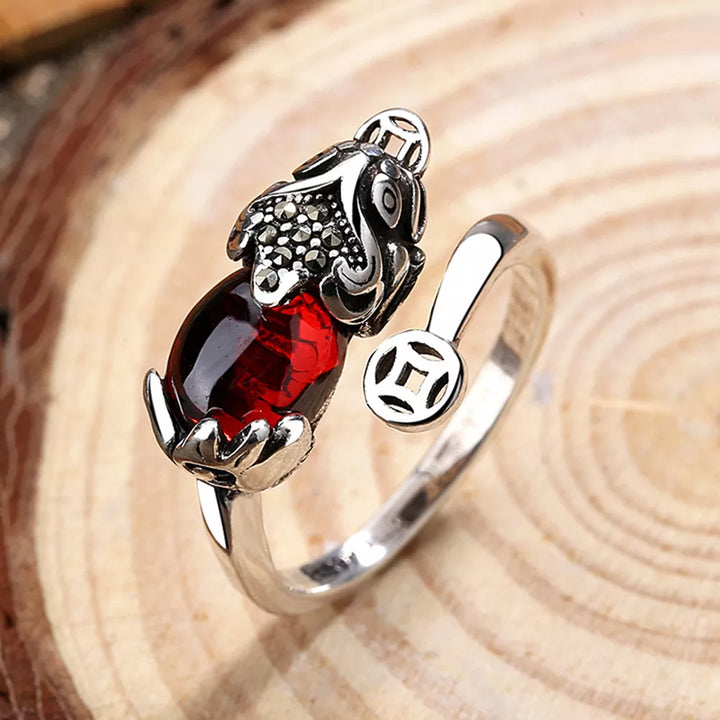 Silberring mit rotem Edelstein und Drachenmotiv, verstellbar, elegantes Schmuckdesign.