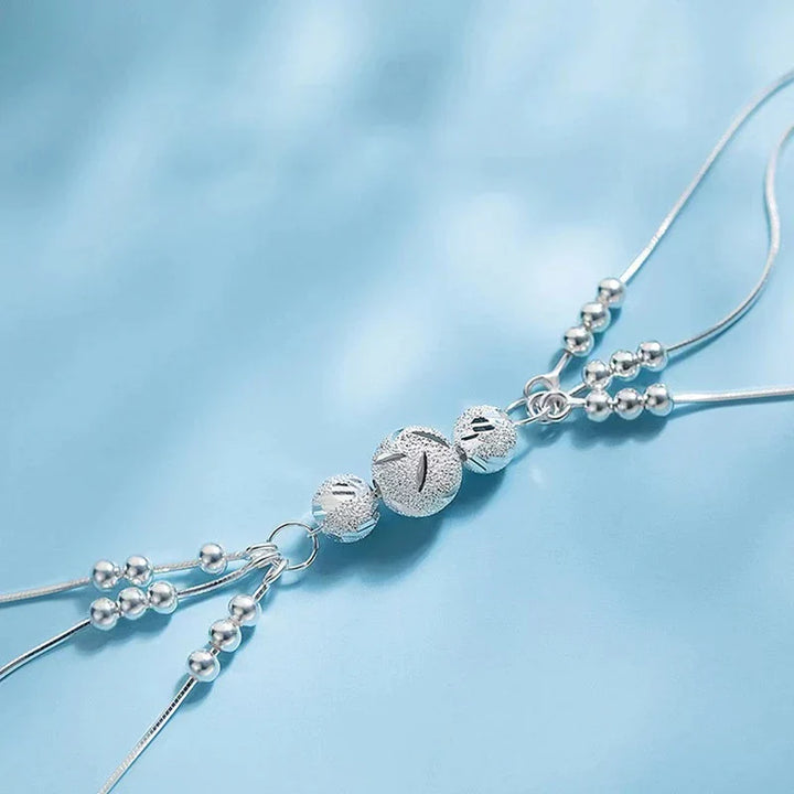 Silberne Armbandkette mit Kugelanhänger, elegantes Schmuckdesign, Damenaccessoire.