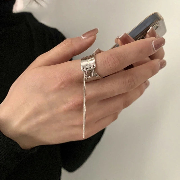 Silberner Ring mit Kette, Damenhand, Smartphone, eleganter Schmuck, modisches Accessoire.