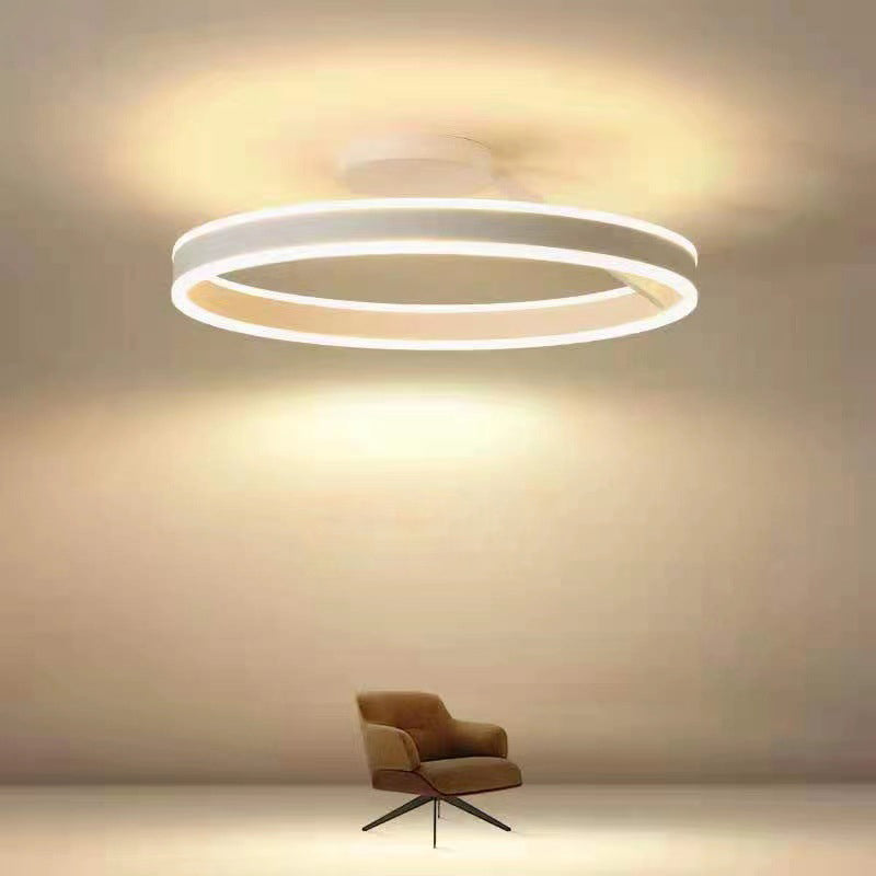 Moderne LED-Deckenleuchte, rund, weiß, energiesparend, über braunem Sessel im Wohnzimmer.