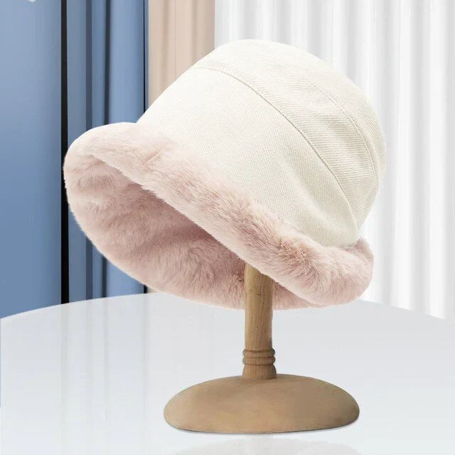 Weißer Damenhut mit rosa Kunstfellrand auf Holzständer, modisch, elegant, Winteraccessoire.