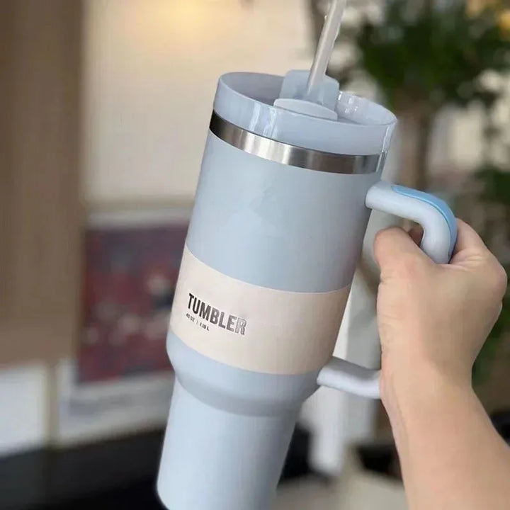 Hellblauer Thermobecher mit Griff, Edelstahl, isoliert, ideal für heiße und kalte Getränke.