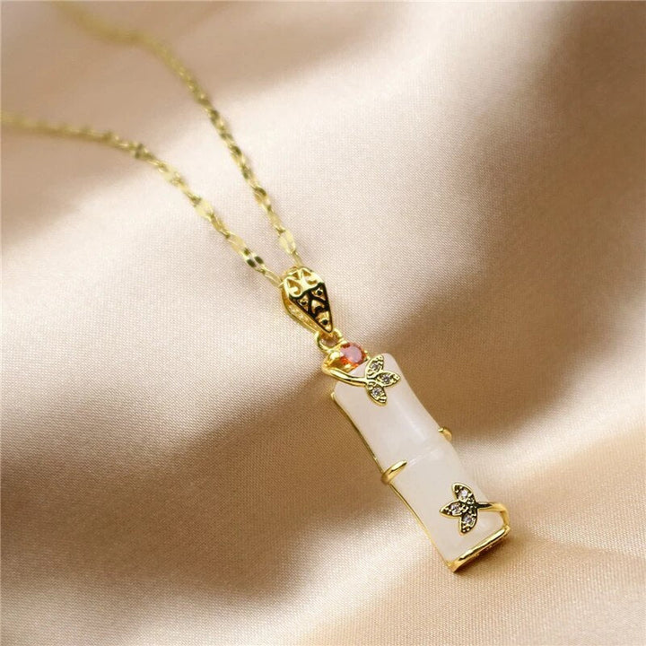 Goldene Halskette mit weißem Anhänger, Schmetterlingsdesign, eleganter Schmuck für Damen.