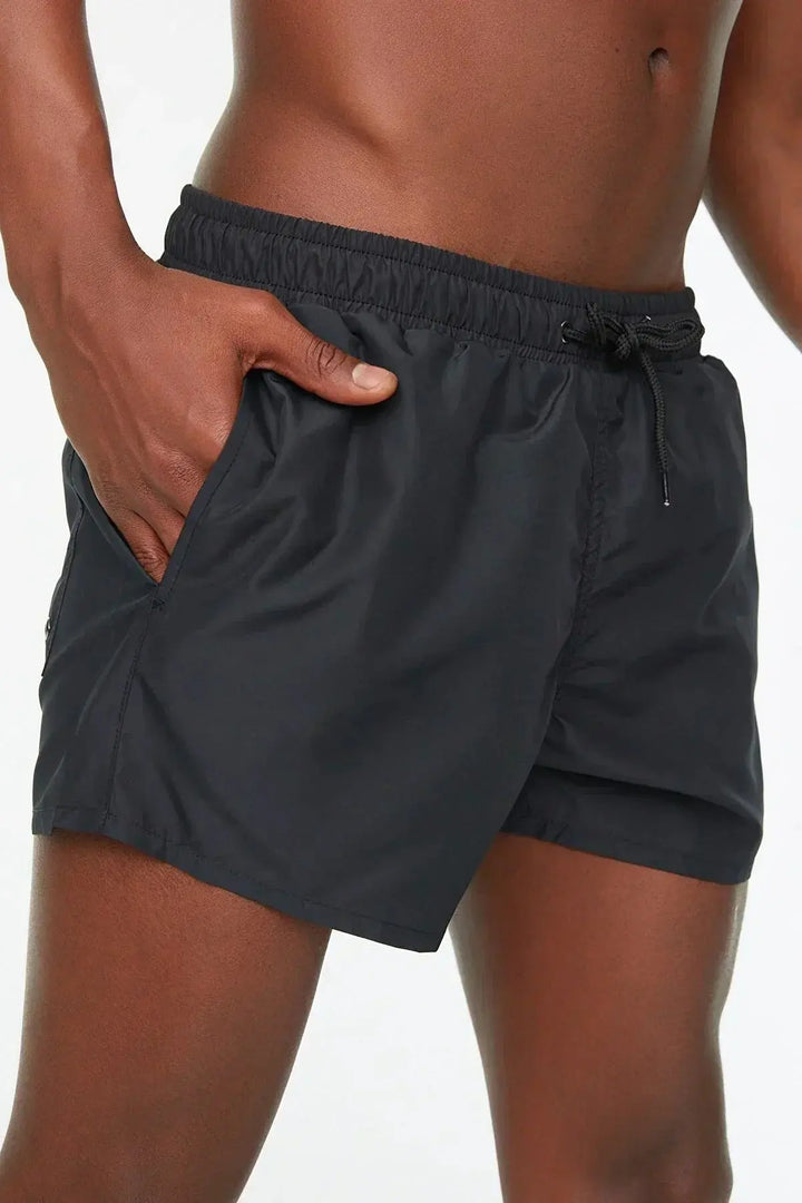 Schwarze Herren-Badeshorts, elastischer Bund, seitliche Taschen, sportlich, bequem.