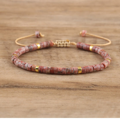 Rotes Steinarmband mit goldenen Akzenten, verstellbar, handgefertigt, Unisex-Schmuck.