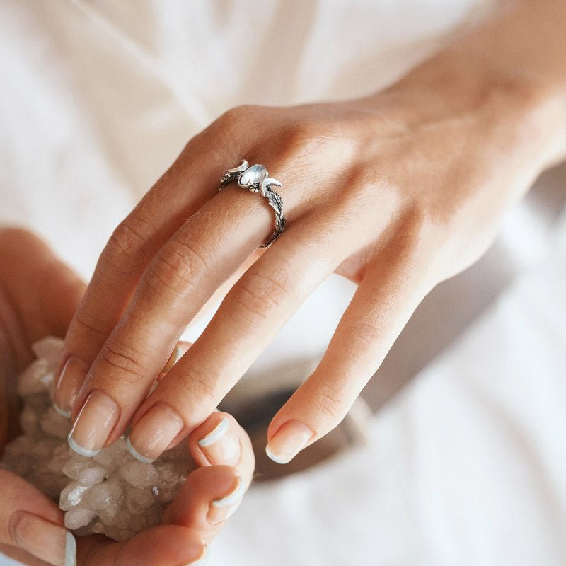 Frau mit silbernem Ring, Perlenbesatz, elegantes Schmuckdesign, Nahaufnahme Hand.