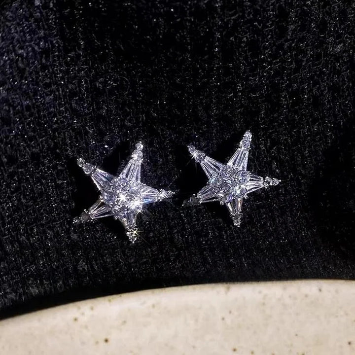Sternförmige Diamant-Ohrringe auf schwarzem Stoff, funkelnd, eleganter Schmuck, Geschenkidee.