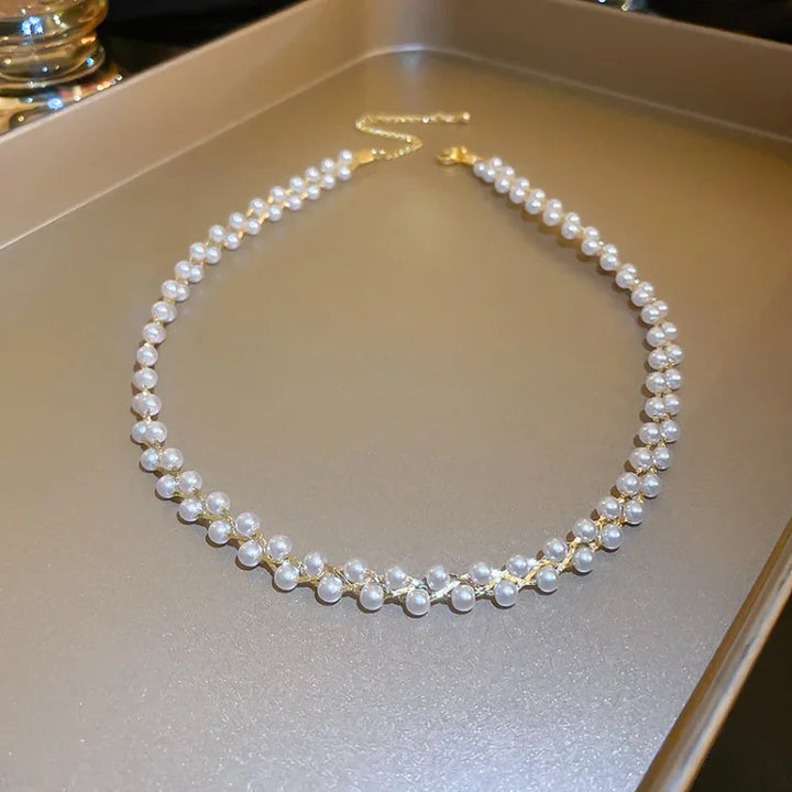 Perlenkette mit goldener Kette auf Tablett, eleganter Schmuck, klassisches Design, Damenaccessoire.
