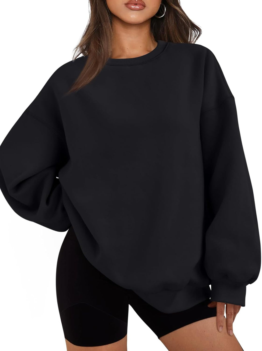 Frau in schwarzem Oversize-Pullover und Shorts, lässige Mode, bequeme Freizeitkleidung.