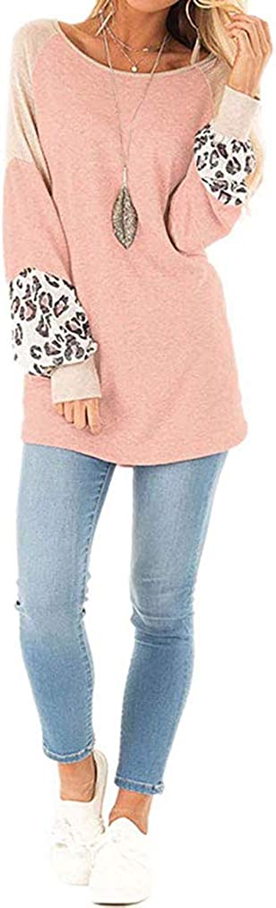 Frau in rosa Pullover mit Leopardenmuster-Ärmeln, blaue Jeans, weiße Sneaker.