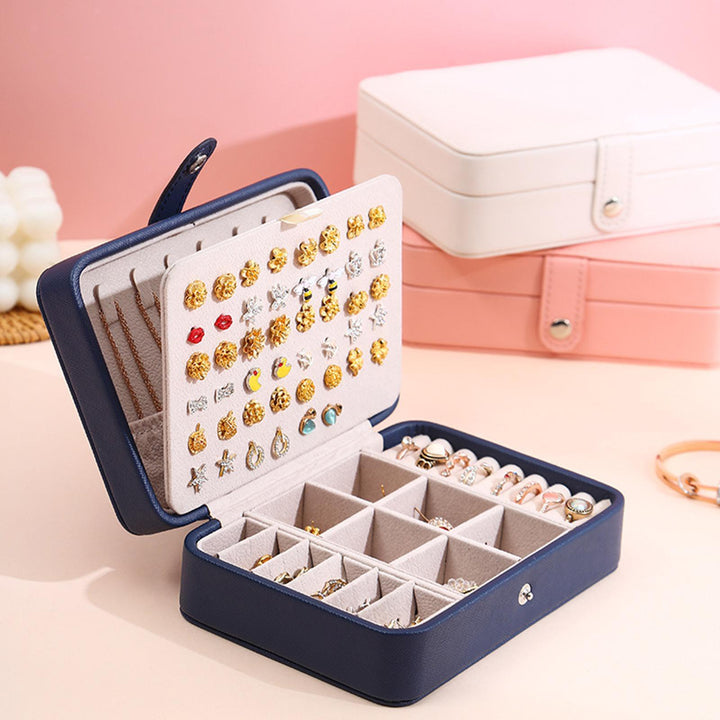 Blaue Schmuckbox mit Ohrring- und Ringfächern, ideal für Schmuckaufbewahrung und Reisen.