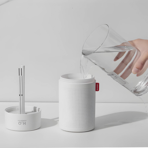 Weiße tragbare Luftbefeuchter mit Wasserbehälter, minimalistisches Design, moderne Raumluftpflege.