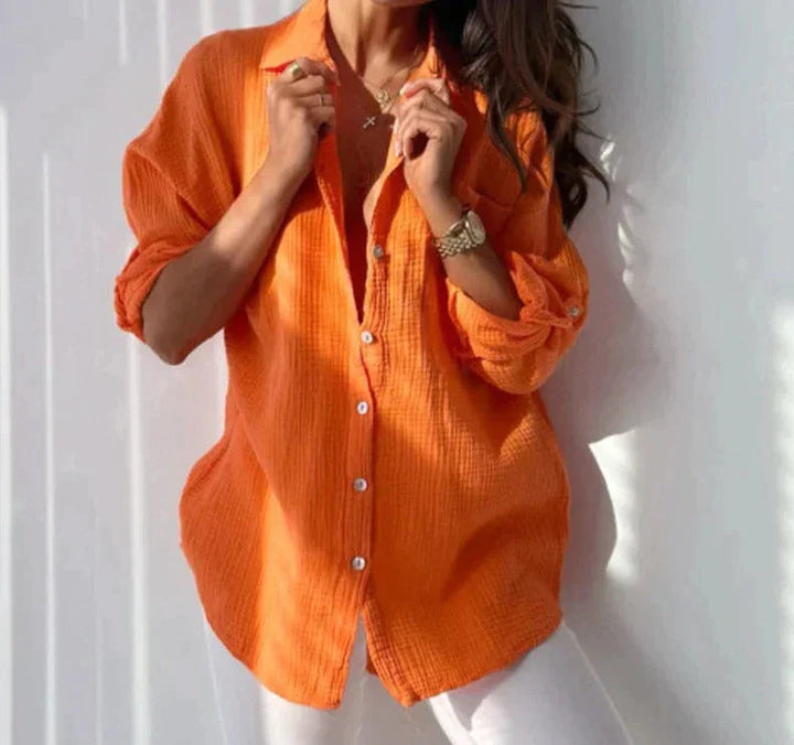Frau in orangefarbener Leinenbluse, lässig geknöpft, modisch, Sommerkleidung, Damenmode.