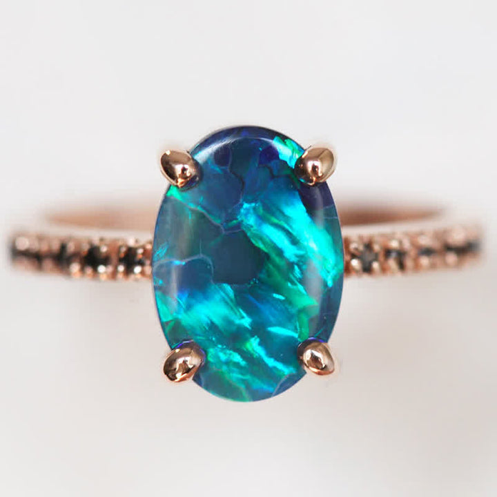 Opalring mit blau-grünem Edelstein, Roségoldfassung, elegantes Schmuckdesign.
