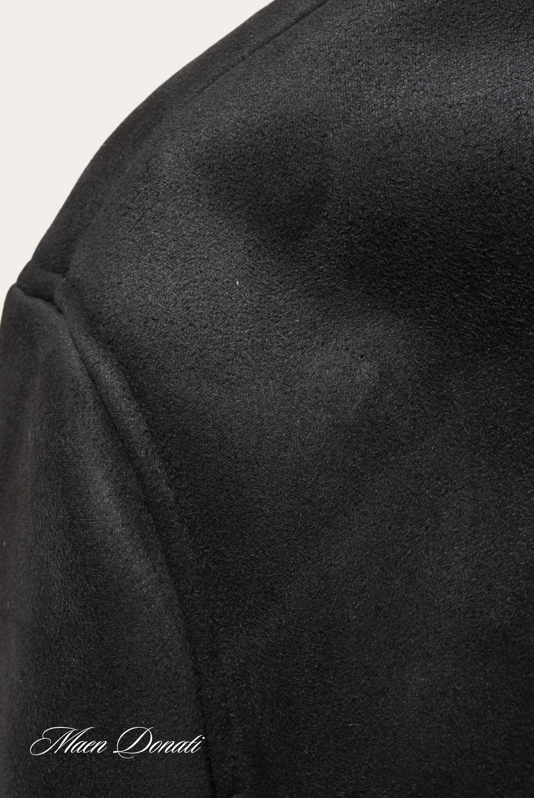 Schwarzer Wollmantel, Nahaufnahme, weiches Material, elegantes Design, hochwertige Mode.