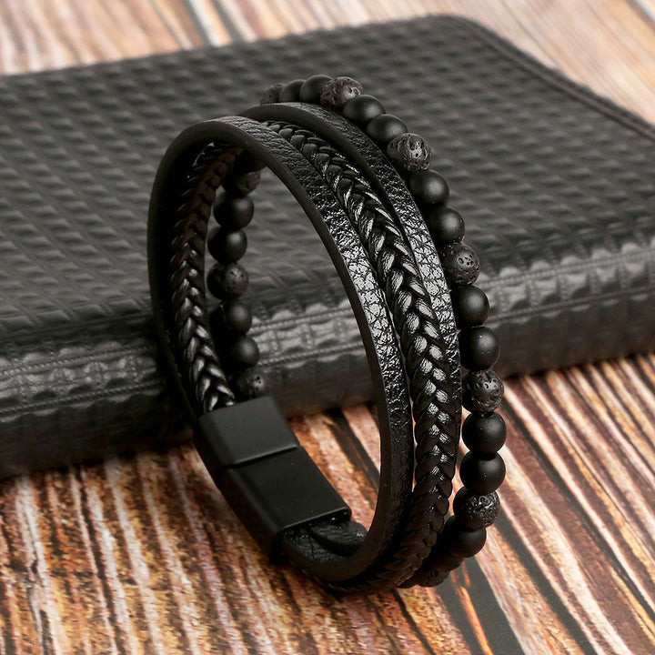 Schwarzes Herrenarmband aus Leder und Perlen, geflochten, auf Holztisch.
