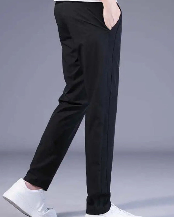 Schwarze Herren-Chinohose, schlank geschnitten, aus Baumwolle, mit weißen Sneakers.