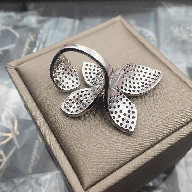 Silberner Blatt-Ring, modernes Design, filigran, auf beigem Schmuckkästchen, Damenmode.