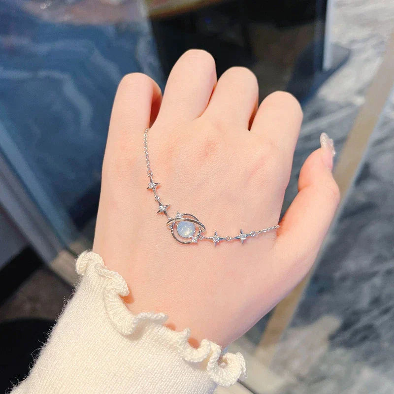 Silbernes Armband mit Mondstein und Sternen auf Hand, eleganter Schmuck für Damen.