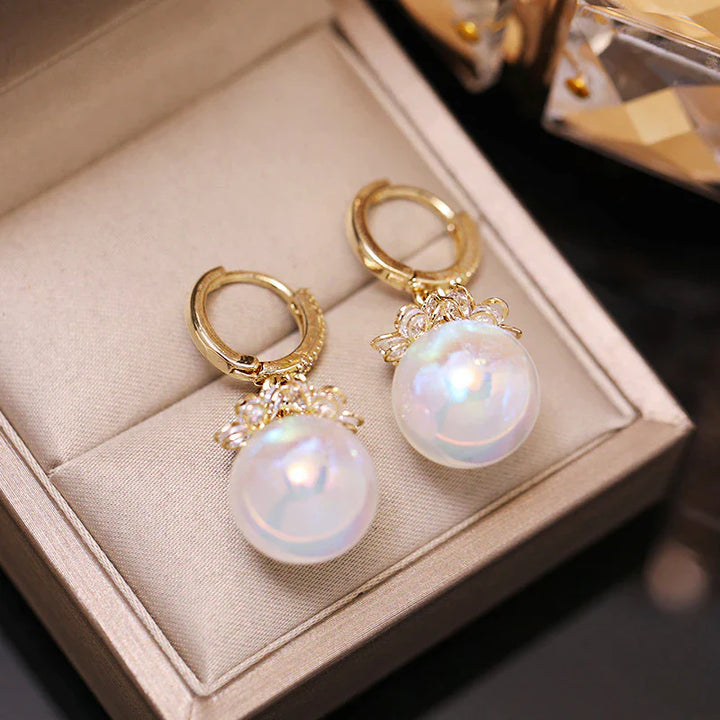 Goldene Ohrringe mit großen Perlen, elegantes Schmuckdesign, luxuriöses Accessoire.