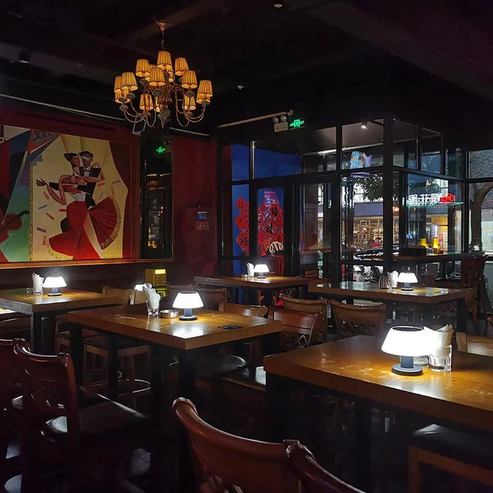 Gemütliches Restaurant mit Holztischen, modernen Tischlampen und farbenfroher Wandkunst.