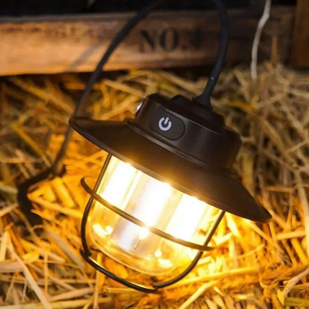 Schwarze LED-Laterne mit Metallkäfig auf Stroh, Vintage-Stil, für Gartenbeleuchtung.