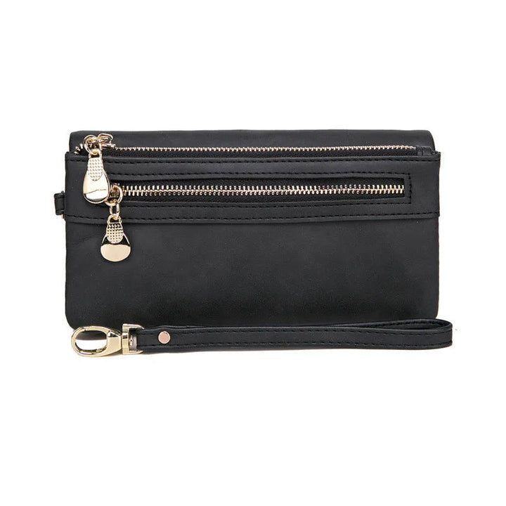 Schwarze Lederhandtasche mit Reißverschlüssen und abnehmbarem Riemen, elegant und praktisch.