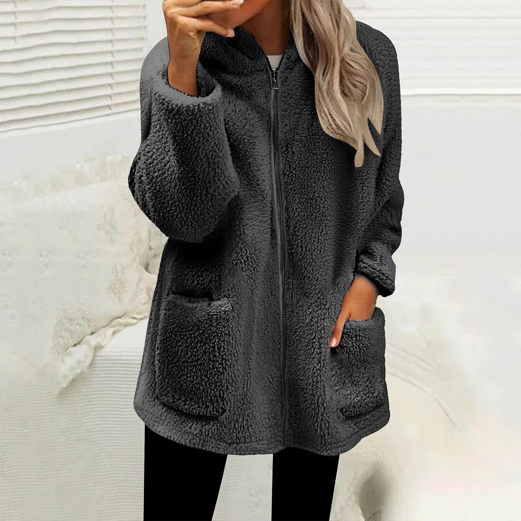 Žena v tmavě šedé chlupaté bundě se zipem a kapsami, ruka v kapse 1