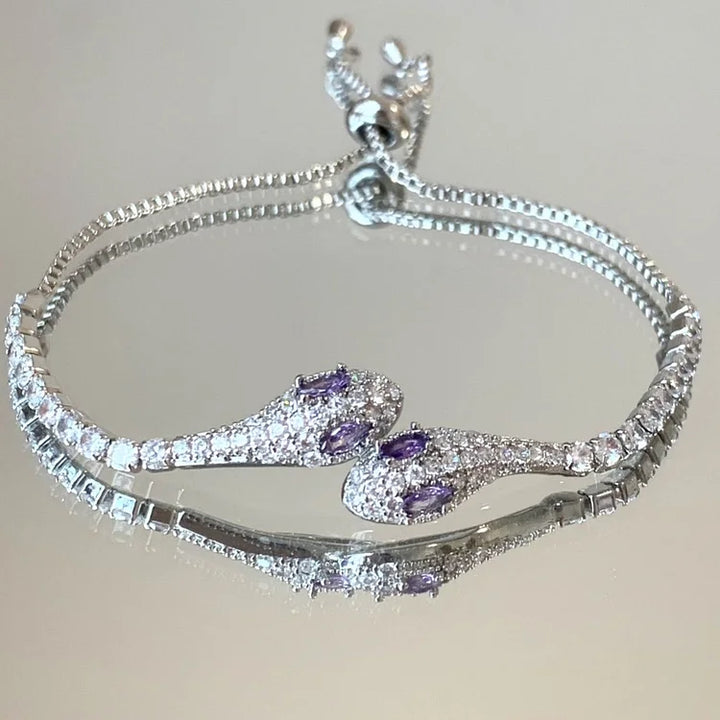 Silbernes Schlangenarmband mit lila Edelsteinen, verstellbar, elegantes Schmuckdesign.