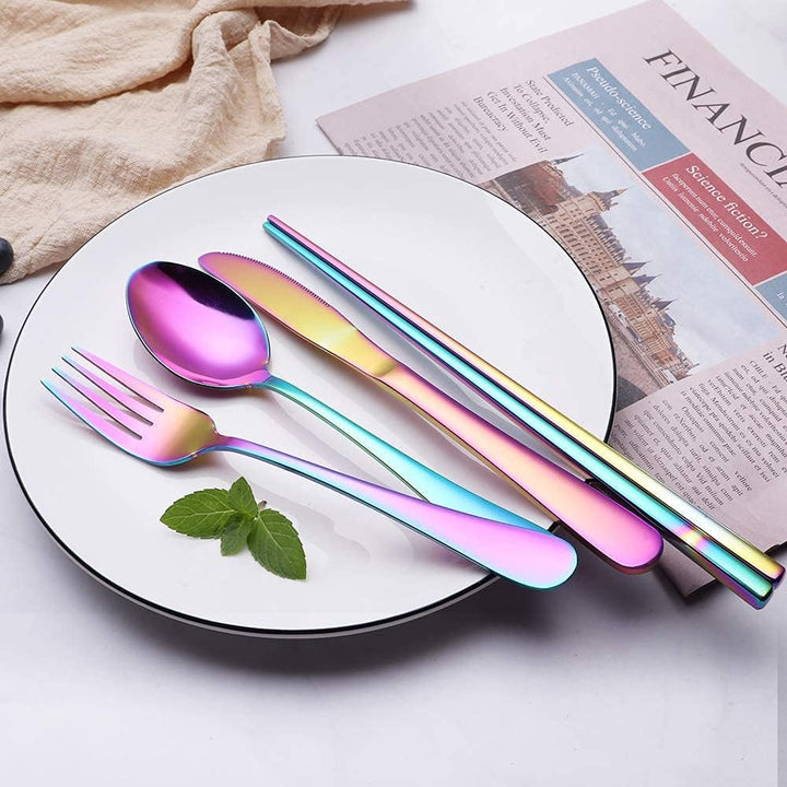 Buntes Edelstahl-Besteckset auf Teller, Regenbogenfarben, Löffel, Gabel, Messer, Essstäbchen.