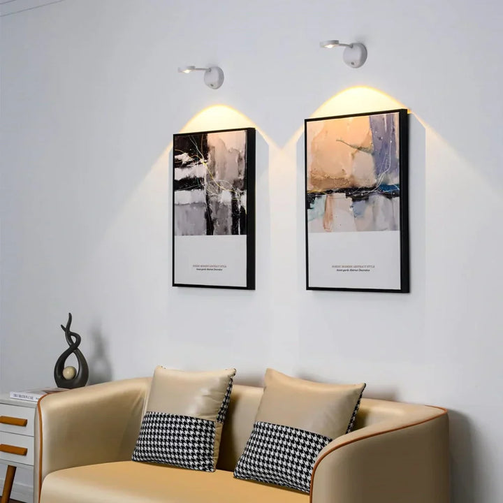 Moderne Wohnzimmerbeleuchtung, LED-Wandleuchten über abstrakten Gemälden, beige Sofa.