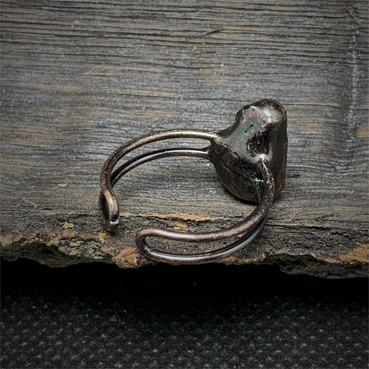 Antiker silberner Ring auf Holzoberfläche, rustikales Design, handgefertigter Schmuck.