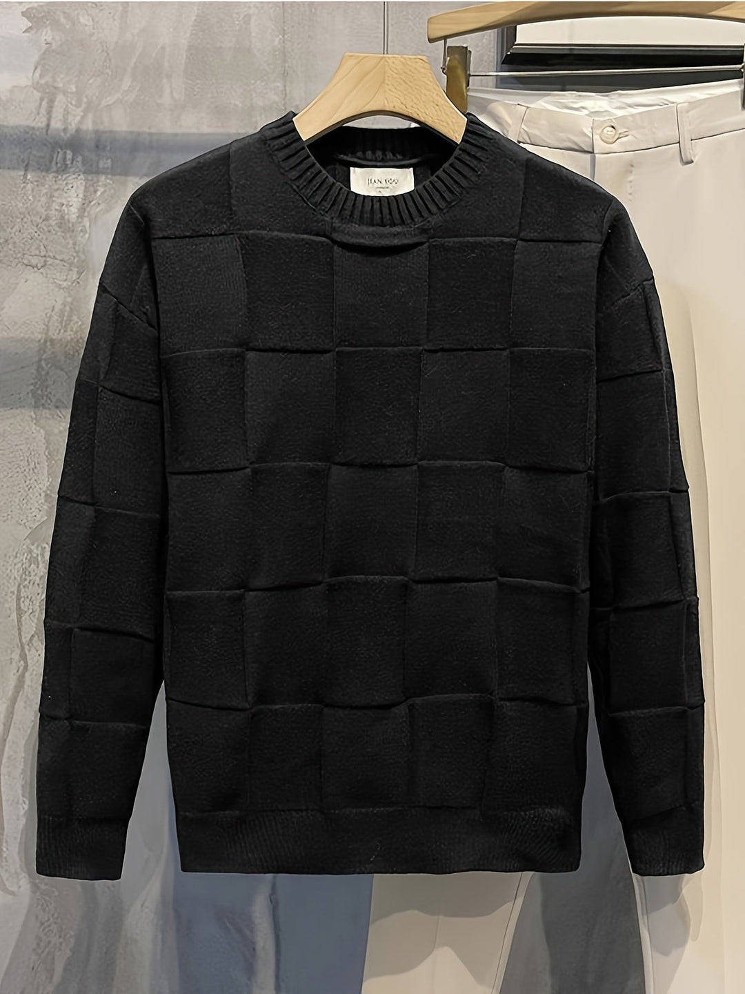 Schwarzer Herrenpullover, Karomuster, Baumwolle, elegant, modisch, Herbstmode, Kleiderbügel.