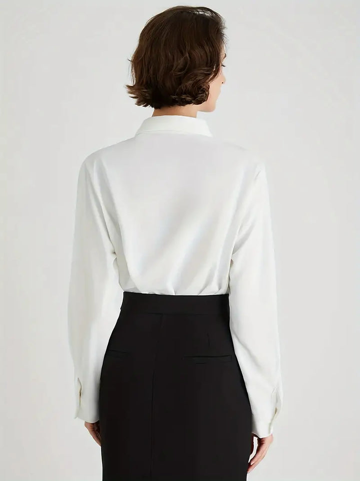 Frau in weißer Bluse und schwarzem Rock, Rückansicht, elegante Business-Kleidung.
