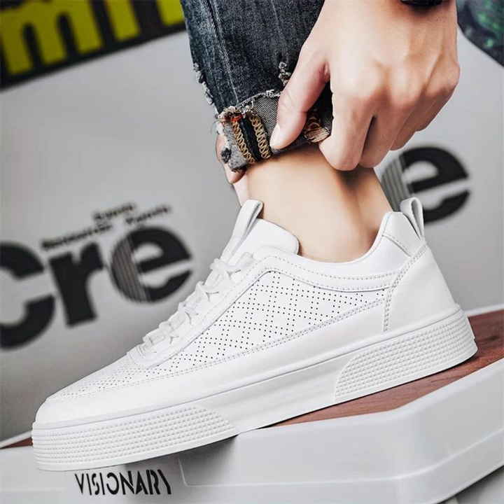 Weiße Sneaker aus Leder, perforiert, modisch, unisex, lässig, auf Holzkiste.