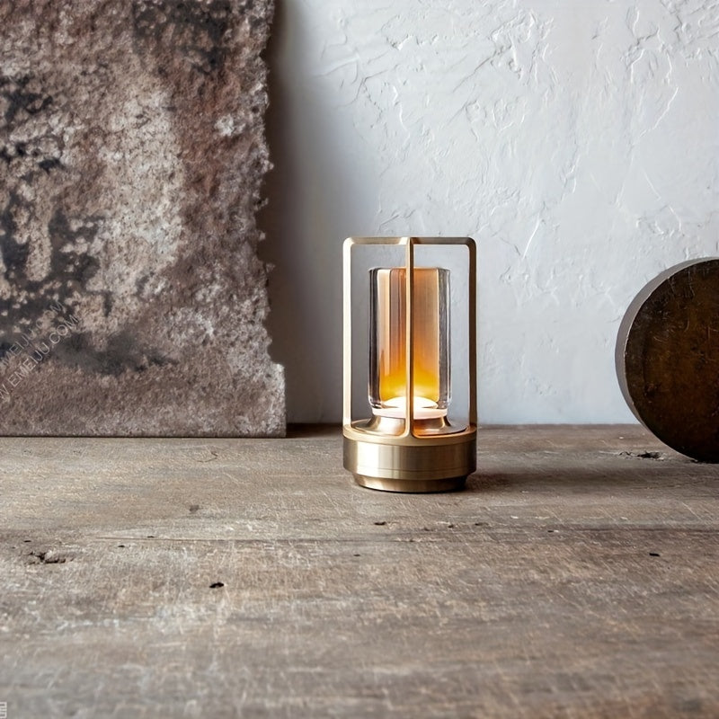 Moderne goldene Tischlampe aus Metall und Glas auf Holzoberfläche, minimalistisches Design.