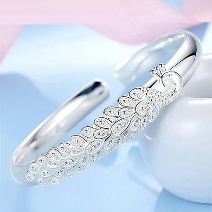 Silbernes Pfauenarmband, elegantes Design, Schmuck für Damen, modisches Accessoire.