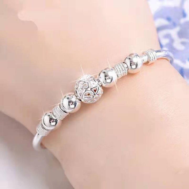 Silberarmband mit glänzenden Kugeln und filigranem Design, eleganter Schmuck für Damen.