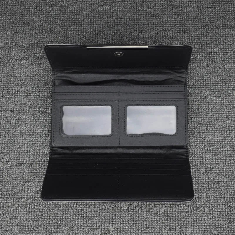 Schwarze Lederbrieftasche mit Kartenfächern und Sichtfenstern auf grauem Hintergrund.