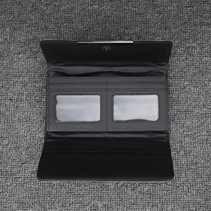 Schwarze Lederbrieftasche mit Kartenfächern und Sichtfenstern auf grauem Hintergrund.