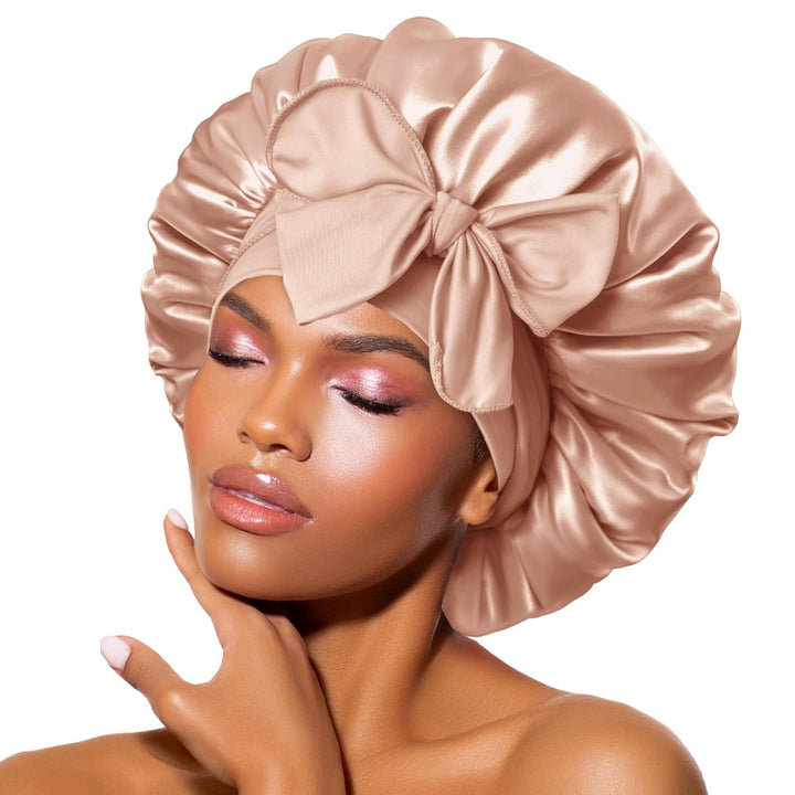 Seidene Schlafhaube in Roségold mit großer Schleife, ideal für Haarpflege und Schutz.