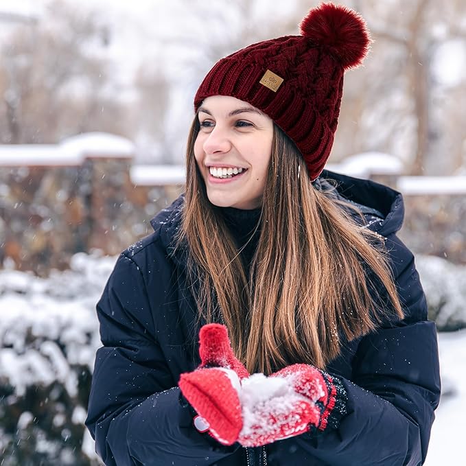 Frau mit roter Strickmütze und Handschuhen im Schnee, Wintermode, Outdoor-Bekleidung.
