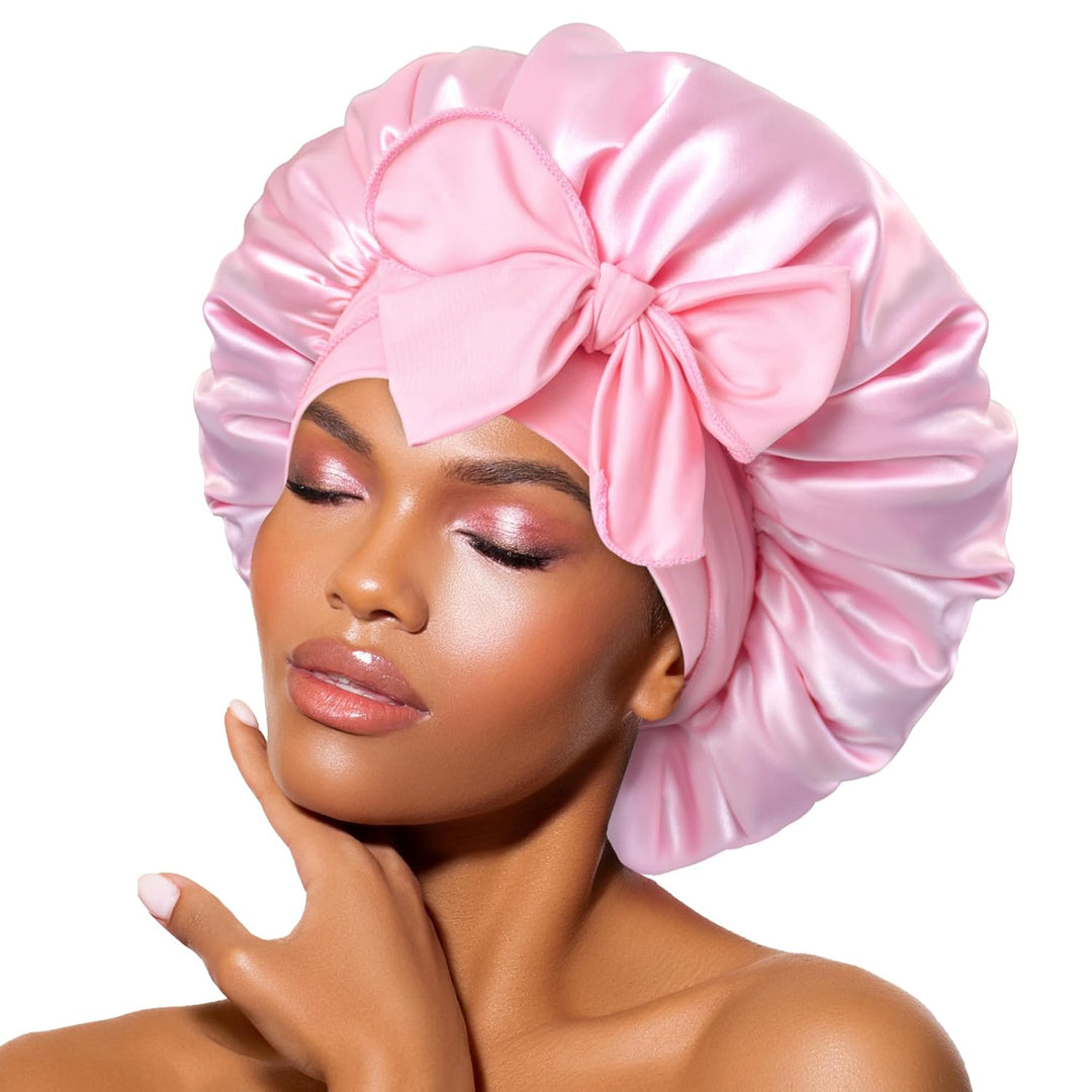 Frau mit rosa Satin-Schlafhaube, großer Schleife, Hautpflege, Haarpflege, stilvoll, elegant.